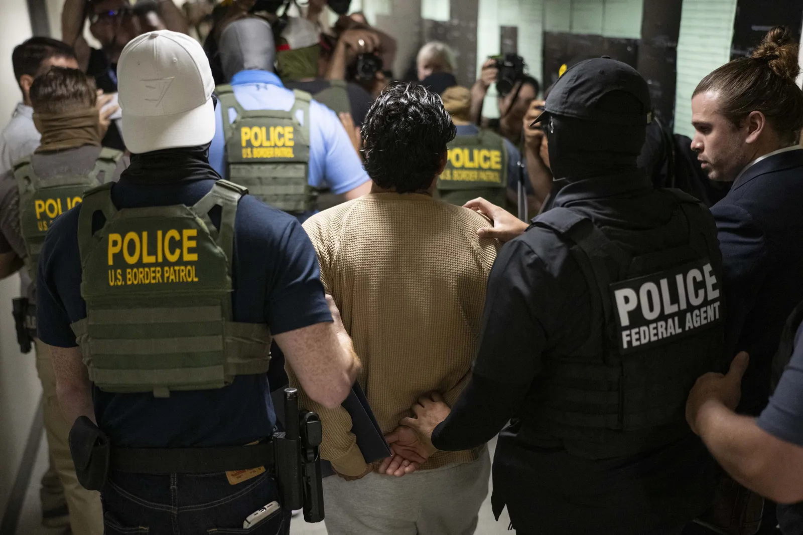Federal agents detain an individual at immigration court, July 2025